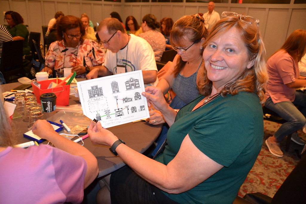 Teacher holding up a microgrid lesson plan