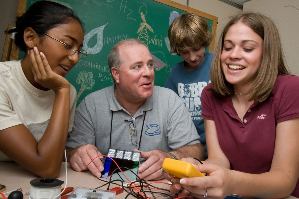 Bob Thompson setting up a science experiment with students in the classroom