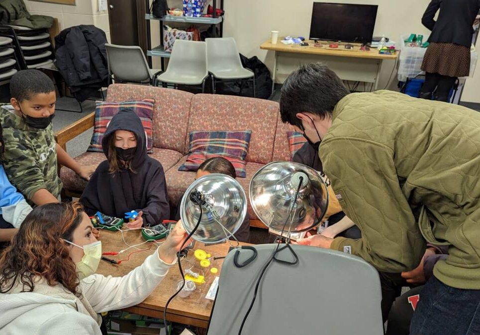 Teacher working with students on a light-based experiment