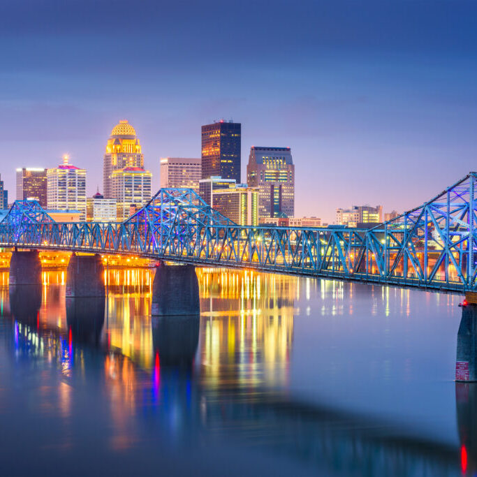 Louisville, Kentucky, USA downtown skyline on the Ohio River at dusk.