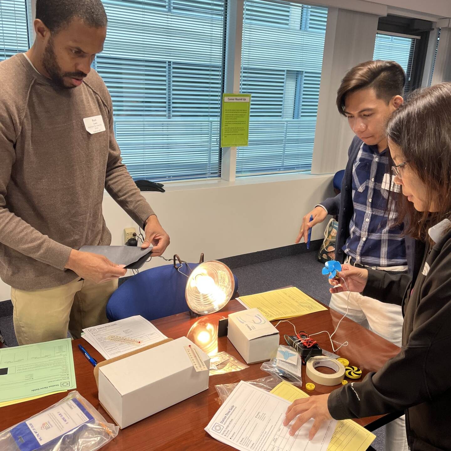 Teachers gathered around a light bulb experiment