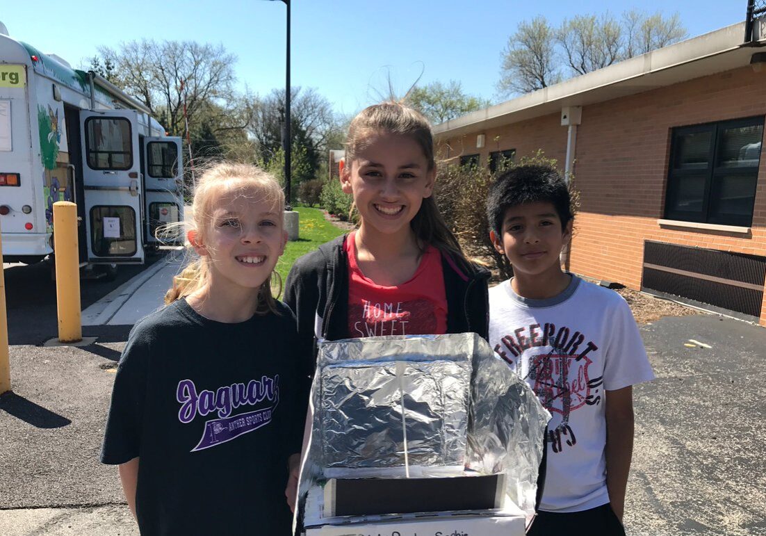 Students demonstrating solar oven