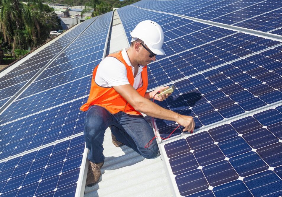 Solar technician inspecting roof panels